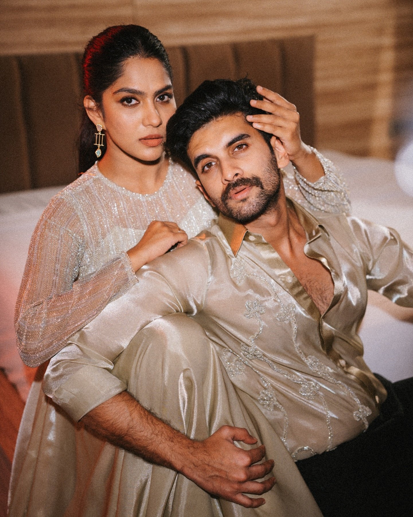 A couple in coordinated ivory outfits posing together