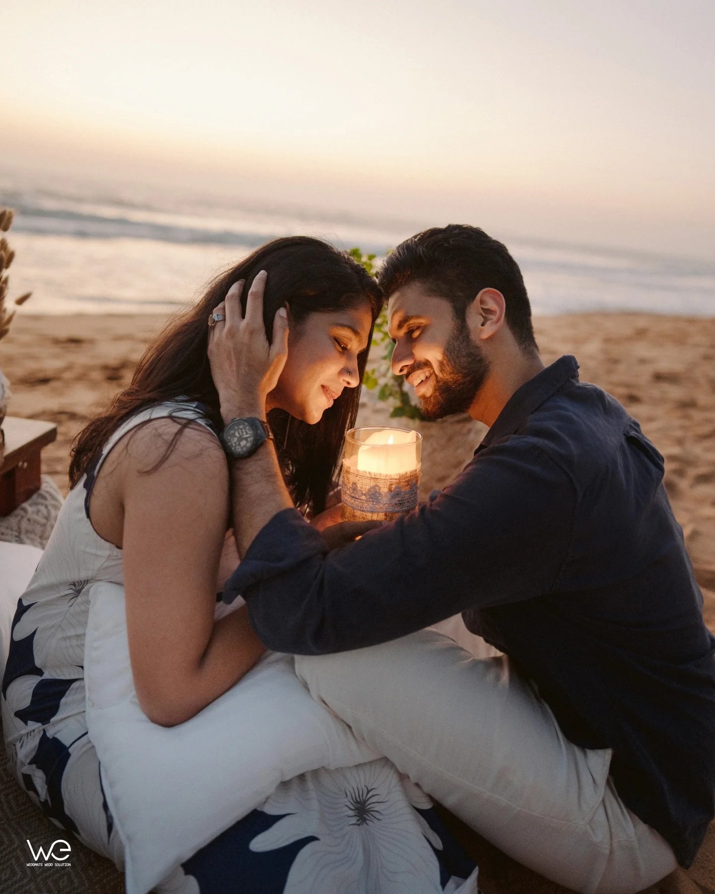 A couple sharing a quiet moment on the beach at sunset