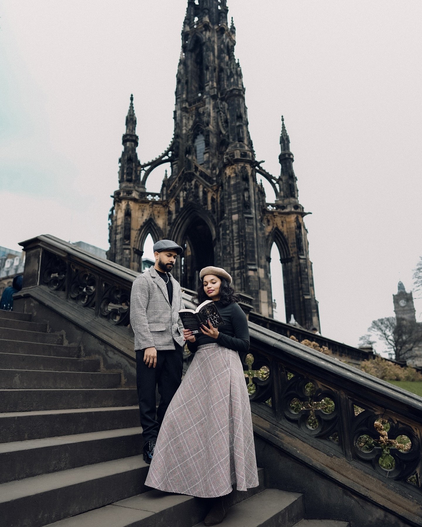 A couple posing on the steps of a Gothic monument