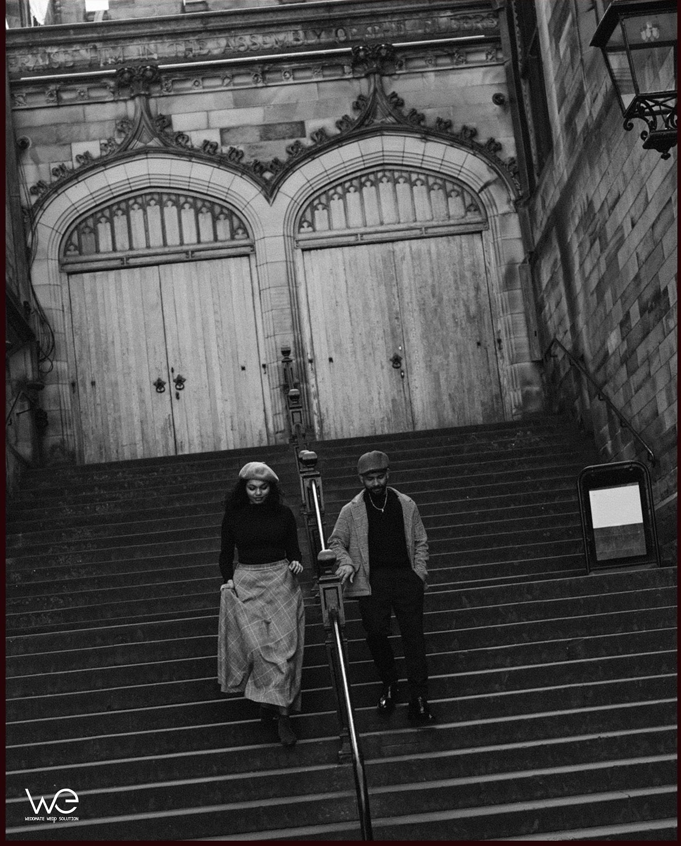 A couple standing before an ornate historic doorway