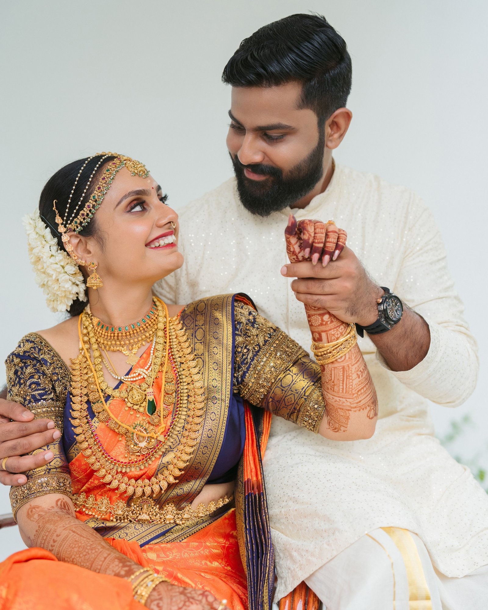 A couple smiling together in traditional wedding attire